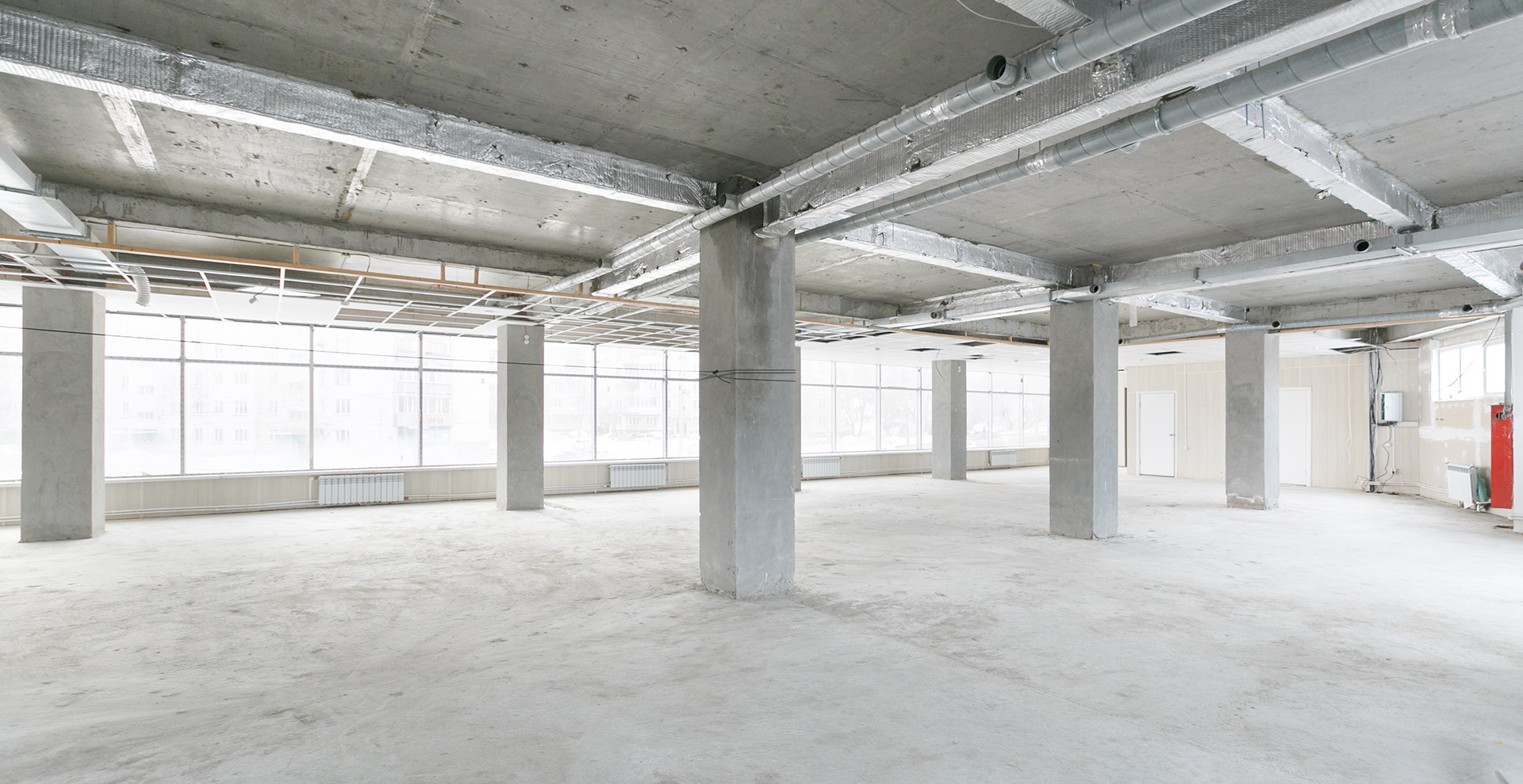 empty concrete open building space with large posts