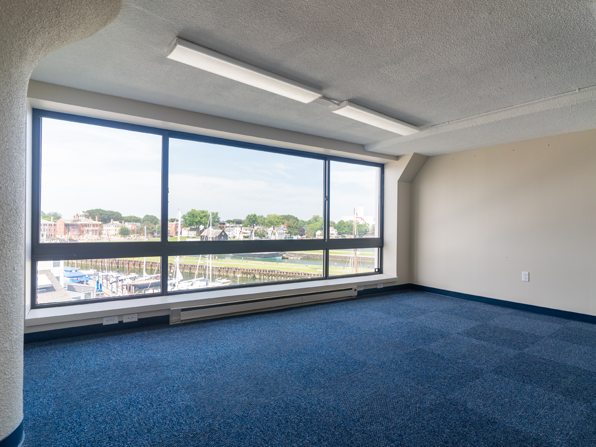 open private office with large window, blue carpet