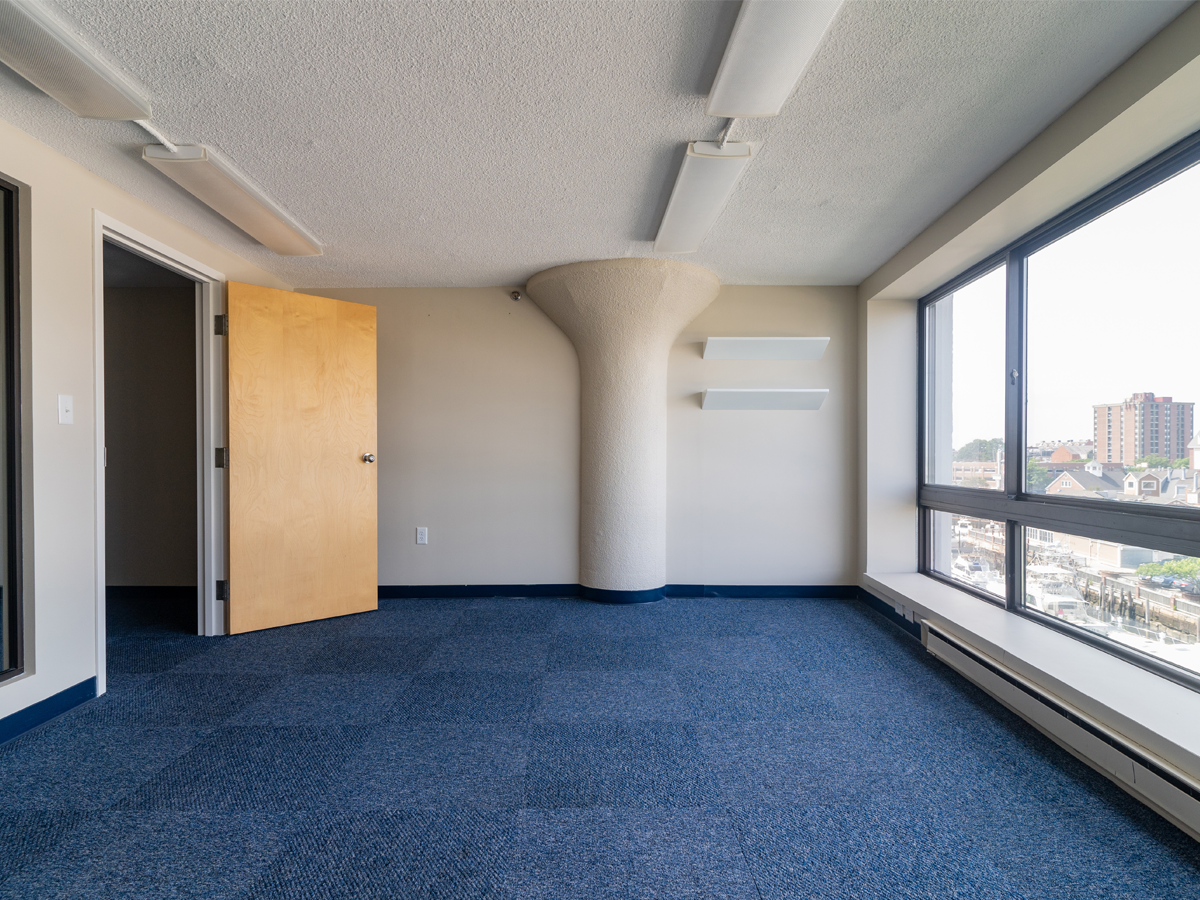 open private office with large window, blue carpet