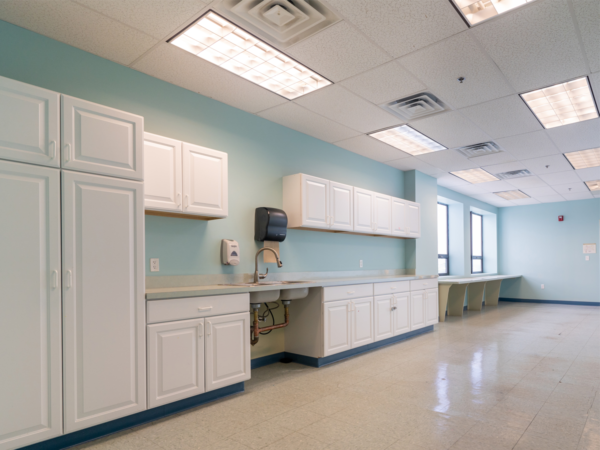 kitchenette area with sink, cabinet storage