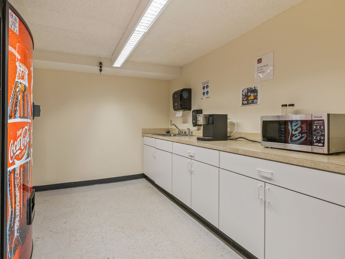 kitchenette with vending machines, sink, coffee machine, microwave